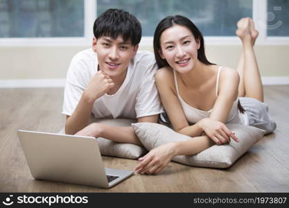 Young couple lying on the floor and using a digital tablet