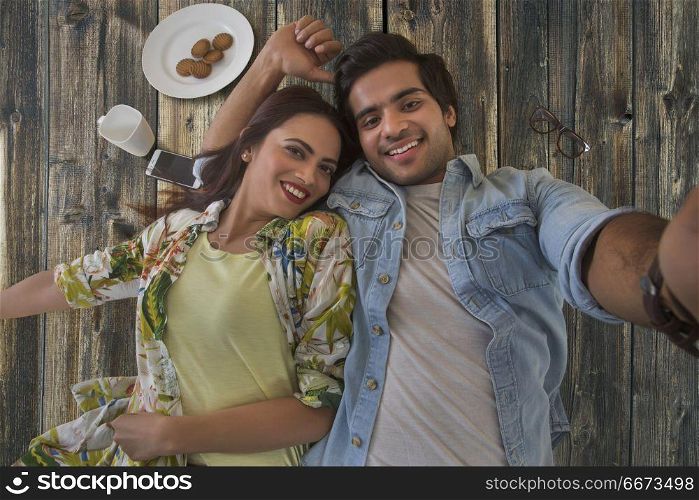 Young couple lying on wooden background