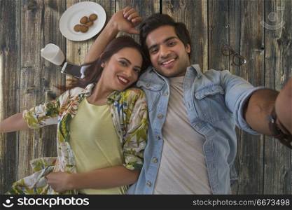 Young couple lying on wooden background