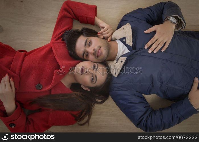 Young couple lying on wooden floor