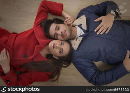 Young couple lying on wooden floor