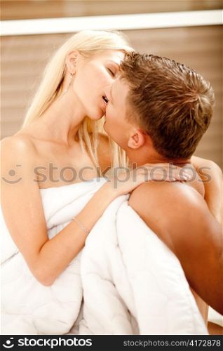 Young couple making love and kissing in bedroom