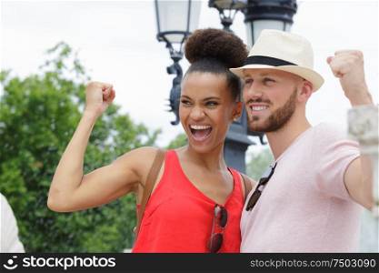 young couple making victory gesture with clenched fist