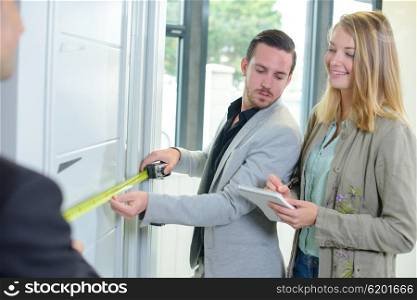 young couple measuring new house