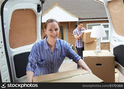 Young Couple Moving In To New Home Unloading Removal Van