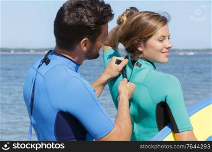 young couple of bodyboard surfers getting ready