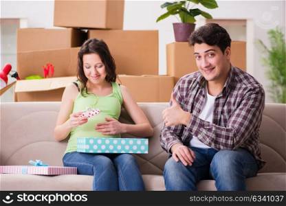 Young couple of man and pregnant wife with giftbox