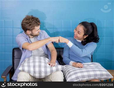Young couple of man and woman with family on sofa - Fist bump.