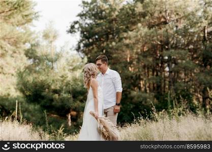 young couple of newlyweds on a walk in a pine forest