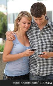 Young couple of students with mobile phone