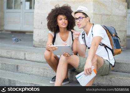 young couple of tourists sitting and discussing next visit