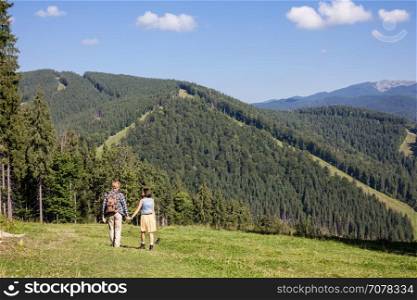 Young couple of travelers enjoying mountain view