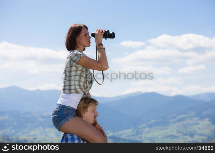 Young couple of travelers looking through binoculars