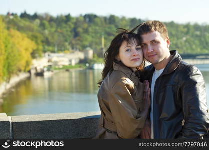 young couple on a bridge on the river