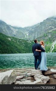 young couple on a walk near the lake surrounded by the Carpathian mountains