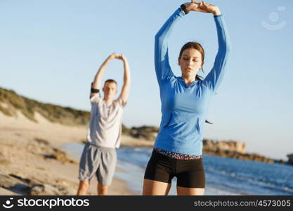 Young couple on beach training together. Young couple on beach training and exercising together