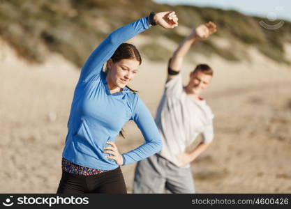 Young couple on beach training together. Young couple on beach training and exercising together