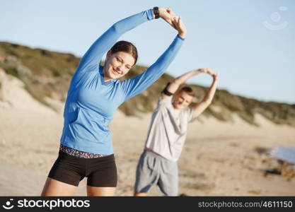 Young couple on beach training together. Young couple on beach training and exercising together