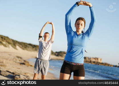 Young couple on beach training together. Young couple on beach training and exercising together