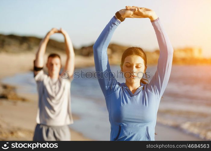 Young couple on beach training together. Young couple on beach training and exercising together