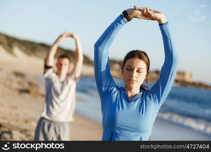 Young couple on beach training together. Young couple on beach training and exercising together