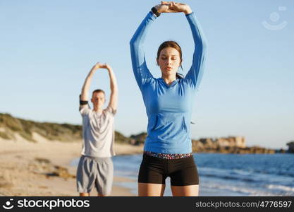 Young couple on beach training together. Young couple on beach training and exercising together