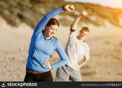 Young couple on beach training together. Young couple on beach training and exercising together