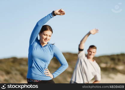 Young couple on beach training together. Young couple on beach training and exercising together