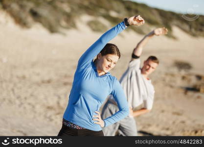 Young couple on beach training together. Young couple on beach training and exercising together