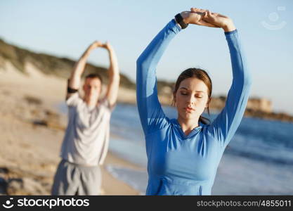 Young couple on beach training together. Young couple on beach training and exercising together