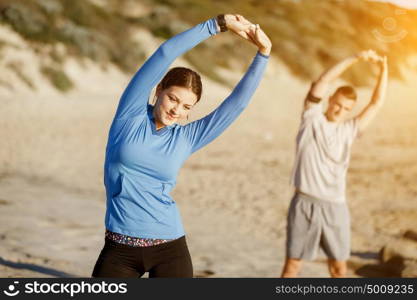 Young couple on beach training together. Young couple on beach training and exercising together