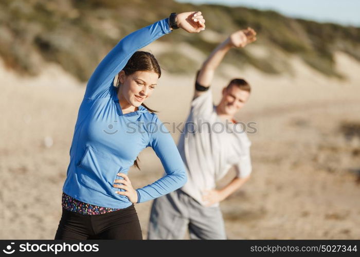 Young couple on beach training together. Young couple on beach training and exercising together