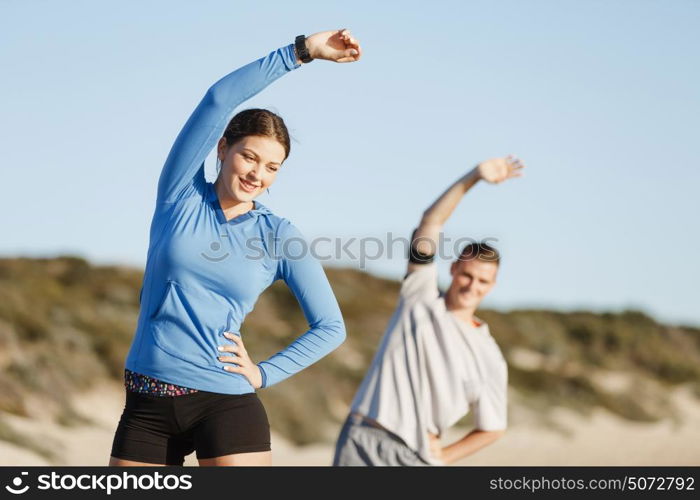 Young couple on beach training together. Young couple on beach training and exercising together