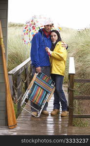 Young couple on beach with umbrella