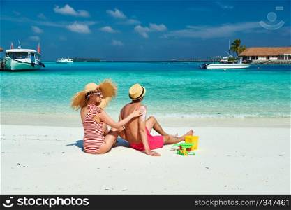 Young couple on beach. Woman applying sun screen protection lotion on man’s back. Summer vacation at Maldives.
