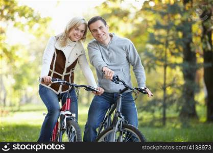 Young couple on bicycles in the park
