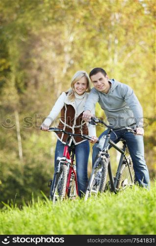 Young couple on bicycles in the park
