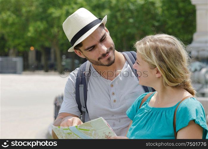young couple on holiday holding map