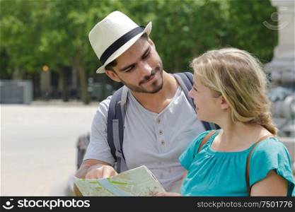 young couple on holiday holding map