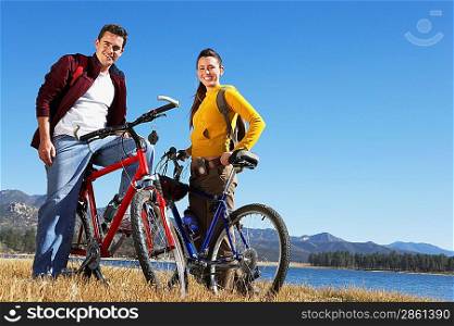 Young Couple on Mountain Bikes by lake