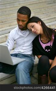 Young couple on some steps with a laptop