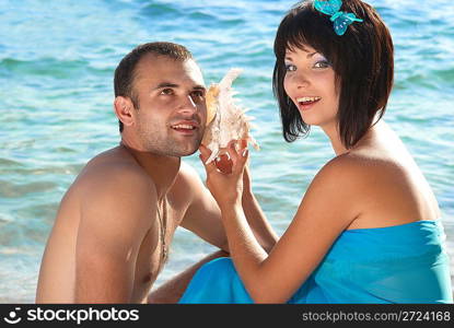 Young couple on the beach with seashell