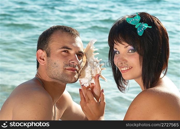 Young couple on the beach with seashell