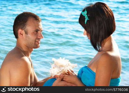 Young couple on the beach with seashell