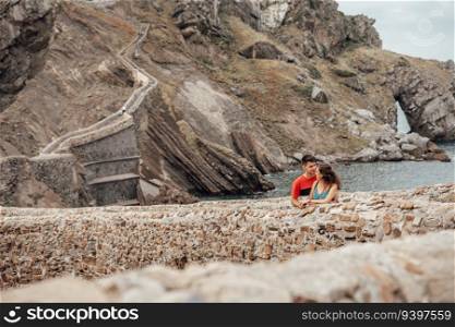 Young couple on the bridge of Gaztelugatxe Island in Vizcaya, Spain