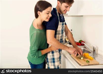 Young couple on the kitchen cooking
