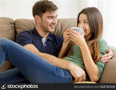 Young couple on the sofa drinking coffee