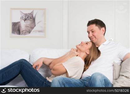 Young couple on the sofa in love planning future and having fun