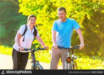 young couple on the weekend to ride a bike in the park