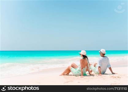 Young couple on white beach during summer vacation. Happy lovers enjoy their honeymoon at exotic island. Young couple walking on tropical beach with white sand and turquoise ocean water